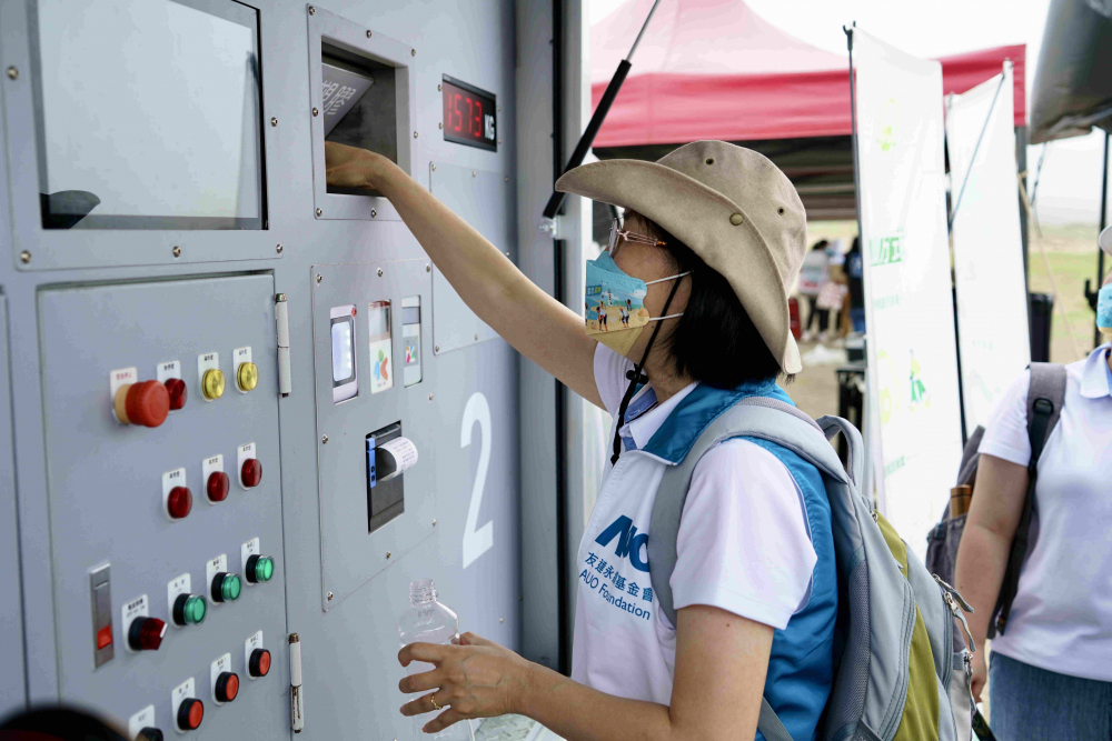 志工們將拾起的寶特瓶投入「好歸塑專車」，讓廢棄塑料空瓶可以直接粉碎、縮小體積，未來將可再製成購物袋、寶特衣、悠遊卡等生活用品