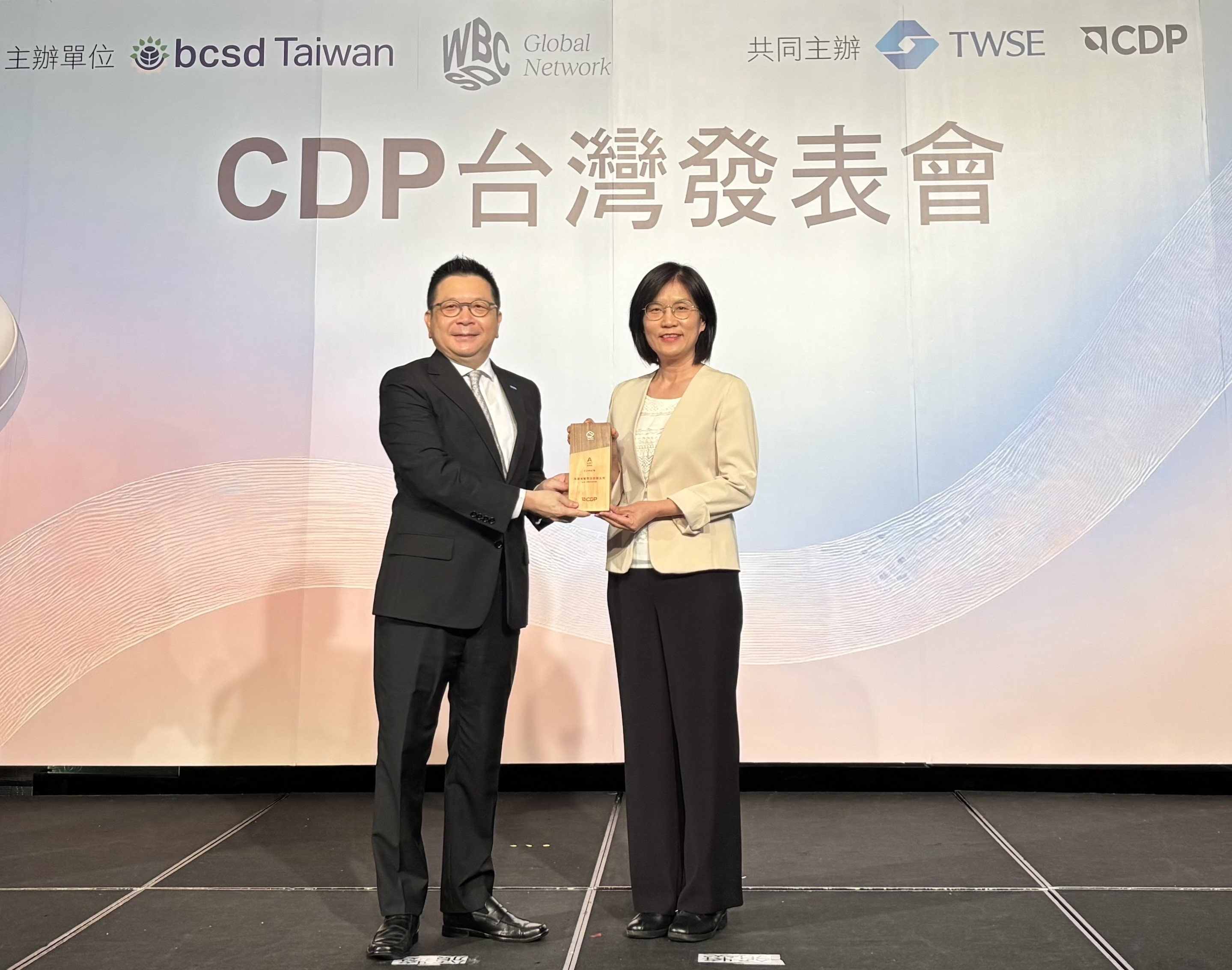 友達永續成果再獲國際評比肯定，獲頒CDP氣候與水資源雙項領導力評級。今由臺灣證券交易所董事長林修銘（左）頒獎，友達光電永續長古秀華（右）代表受獎